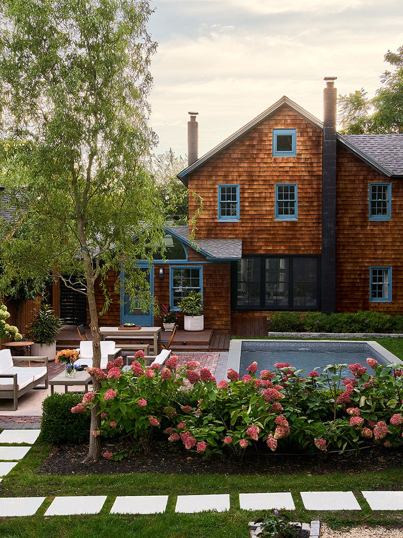 Exterior of home with cedar shake siding and a pool