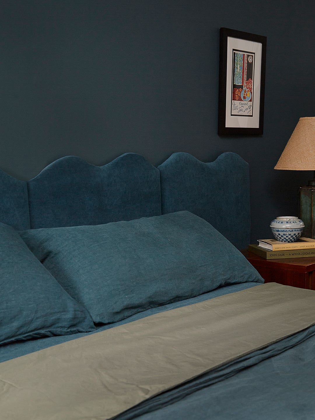 teal bedroom with wavy velvet headboard